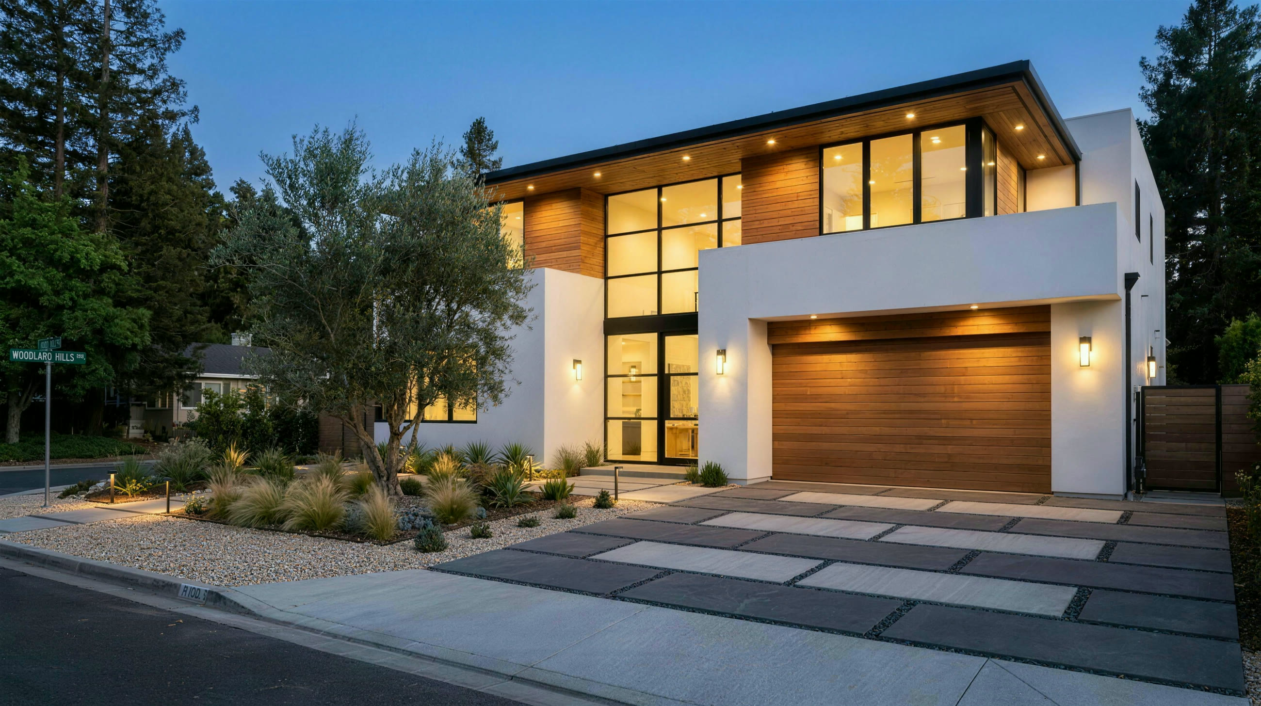 Contemporary California home front elevation at dusk with modern two-tone basketweave driveway